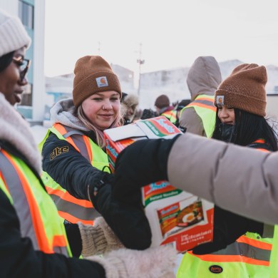 Non-perishable donations cross Franklin Avenue with the help of high school students. Sarah Pruys/Cabin Radio