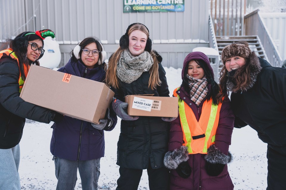 A group of girls pauses for a photo as they pass food down from St Pat's. Sarah Pruys/Cabin Radio