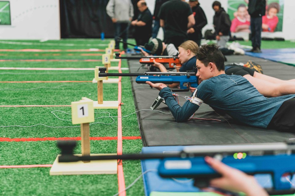 Biathletes practice shooting with electronic rifles at Yellowknife's Fieldhouse. Sarah Pruys/City of Yellowknife