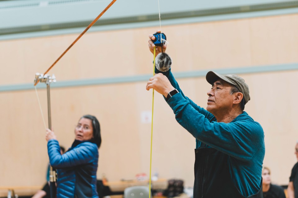 Volunteers measure the height of the sealskin ball at Alaskan high kick trials. Sarah Pruys/City of Yellowknife