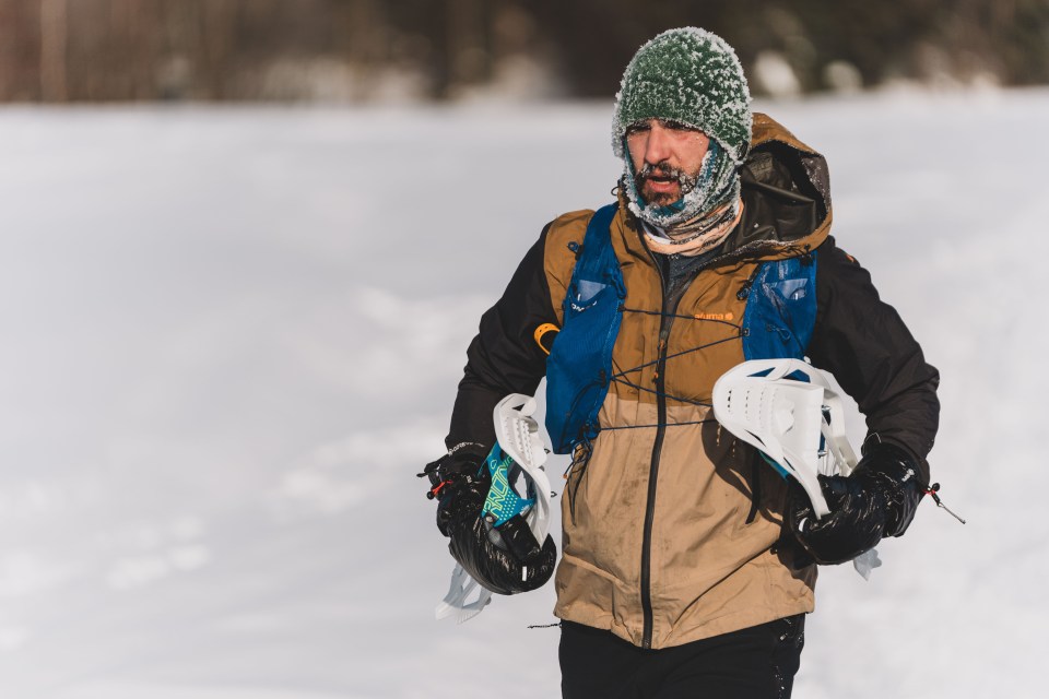 A snowshoer carries his snowshoes while jogging the course in 2025. Sarah Pruys/The Frostbite