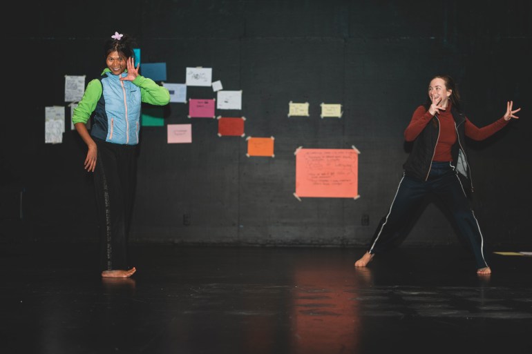 Chollada Phinitduang, left, and Fia Grogono dance to a Finnish voice note. Sarah Pruys/Cabin Radio