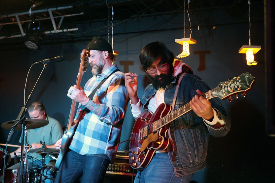 3 men perform on stage