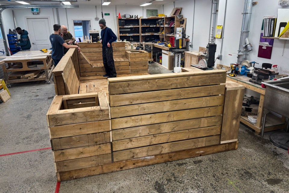 Ben Corbin, top centre, discusses the parklet with Adam Denley and Dwayne Wohlgemuth. Ollie Williams/Cabin Radio