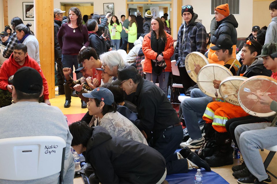 A group of people circle the players of hand games