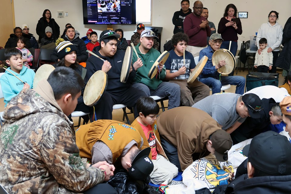 Group of boys and men gather to play a game and drums