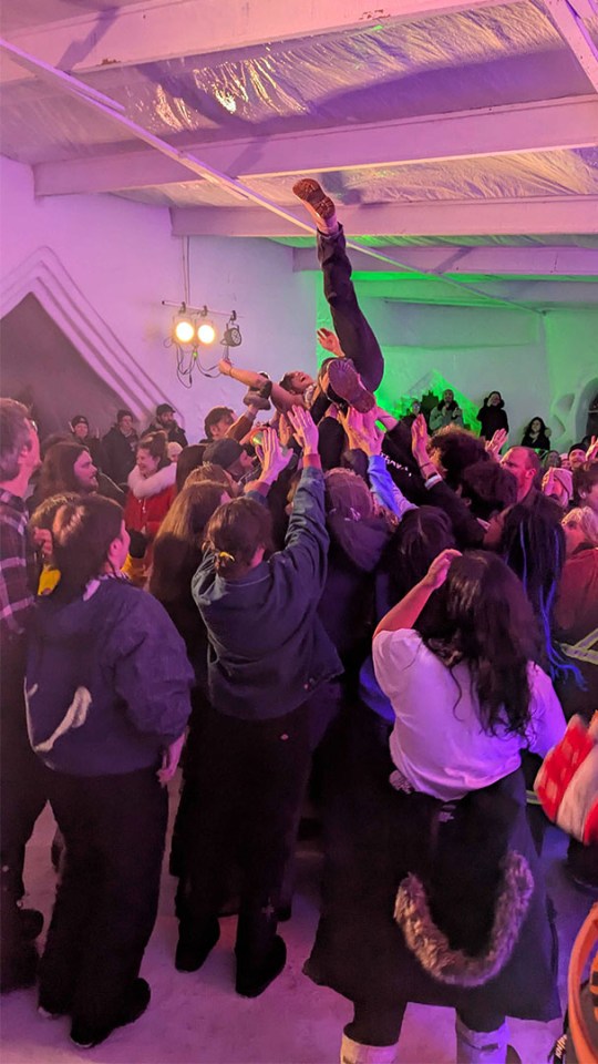 Woman is carried by the crowd during a punk show