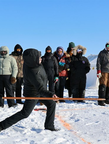 woman gets ready to throw a long stick as part of a game