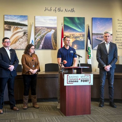 Hay River senior administrator Glenn Smith, flanked by NWT MP Rebecca Alty and Premier RJ Simpson, at a news conference on April 7, 2026. Aastha Sethi/Cabin Radio