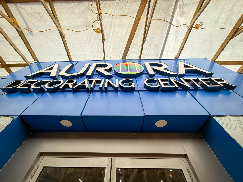Aurora Decorating Center's new sign is kept literally under wraps at the 50 Avenue location. Ollie Williams/Cabin Radio