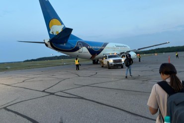 Evacuees head to a Canadian North flight late on June 28, 2026. Photo: Submitted