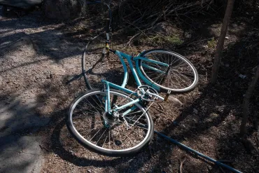 A bike ditched on the side of a trail along Frame Lake with the seat removed. Kai Wilson/Cabin Radio