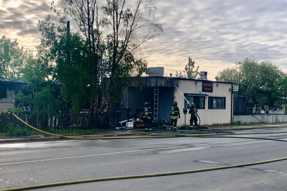 Firefighters address the aftermath of a fire on Yellowknife's 49 Street early on June 18, 2026. Alice Twa/Cabin Radio