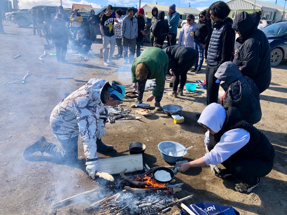 Residents take part in the bannock making competition outside Kitti Hall. Cody Punter/Cabin Radio