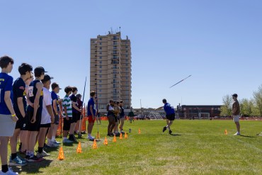 Ethan Strader begins the javelin at Track and Field 2026 with fellow contenders looking on. Ollie Williams/Cabin Radio