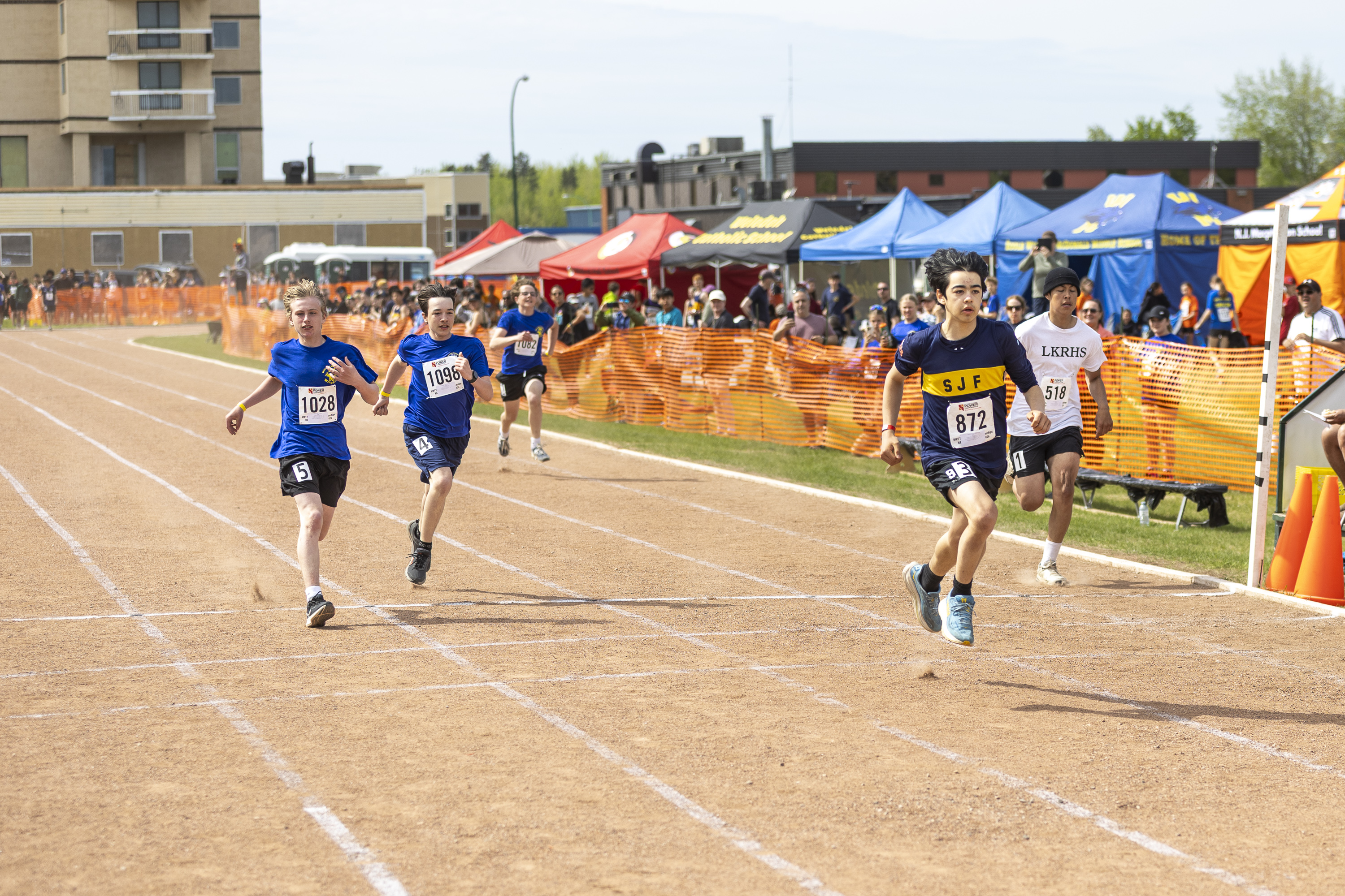 Sir John Franklin High School's Michael Murphy, second from right, wins a 100m heat. Ollie Williams/Cabin Radio