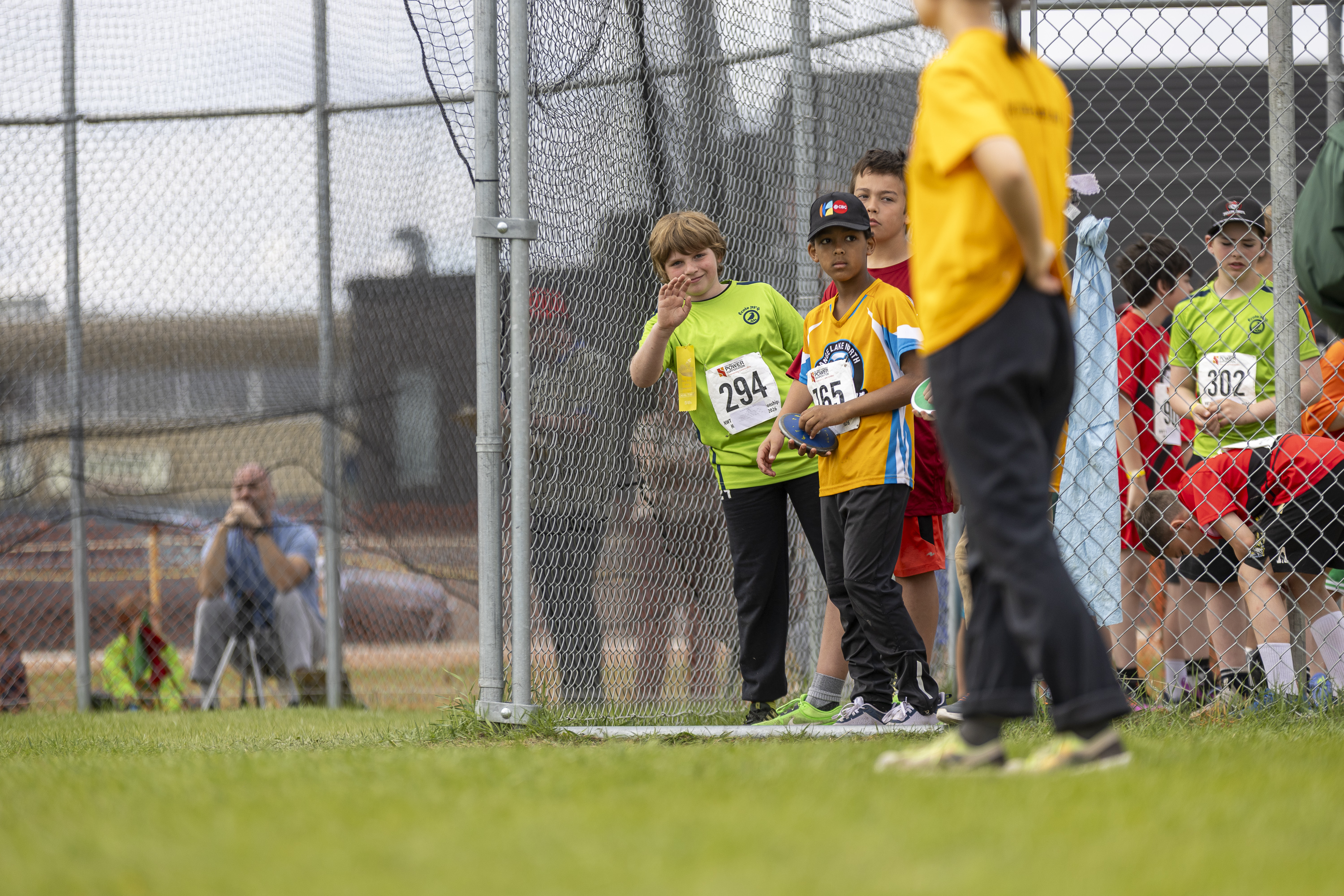 Samuel Sansfacon, left, spots the camera while waiting for a discus attempt. Ollie Williams/Cabin Radio