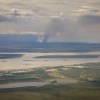 A wildfire burns in the distance across the Mackenzie River from Norman Wells on June 15, 2026. Ollie Williams/Cabin Radio