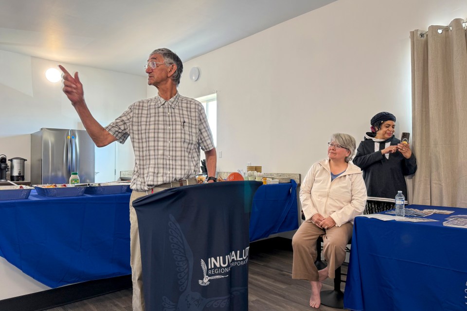 Jeffrey Amos, left, gestures toward a room of Inuvik's transitional housing facility during a ceremony to celebrate its opening. Ollie Williams/Cabin Radio
