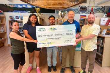 Representatives from the Northern Store present a cheque to the Hamlet of Fort Liard for upgrades to the baseball diamond. Photo: Submitted
