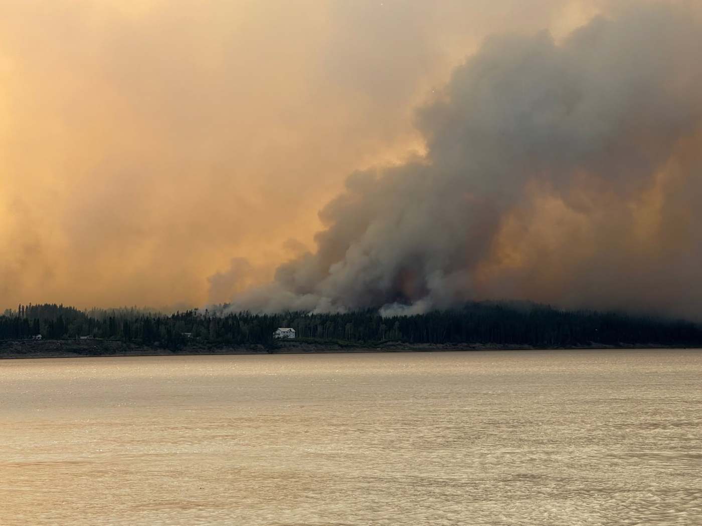 Bannockland, a Fort Simpson hotel, is seen with wildfire smoke behind it on July 3, 2026. Photo: Murray Sibbeston