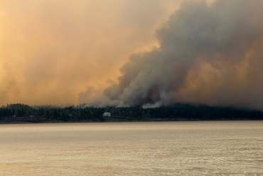 Bannockland, a Fort Simpson hotel, is seen with wildfire smoke behind it on July 3, 2026. Photo: Murray Sibbeston