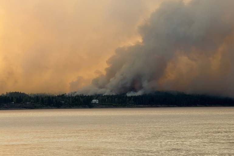Bannockland, a Fort Simpson hotel, is seen with wildfire smoke behind it on July 3, 2026. Photo: Murray Sibbeston
