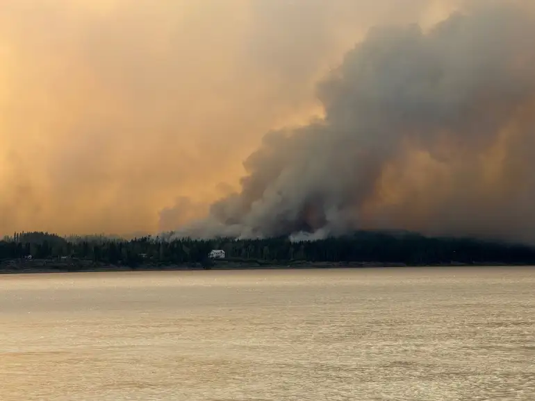 Bannockland, a Fort Simpson hotel, is seen with wildfire smoke behind it on July 3, 2026. Photo: Murray Sibbeston