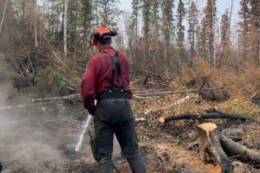 Wildfire personnel extinguishing a deep burning ash pit on July 12, 2026. Photo: NWT Fire
