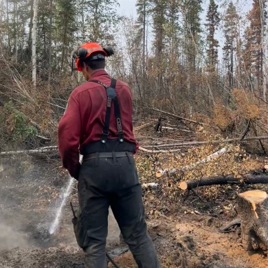 Wildfire personnel extinguishing a deep burning ash pit on July 12, 2026. Photo: NWT Fire