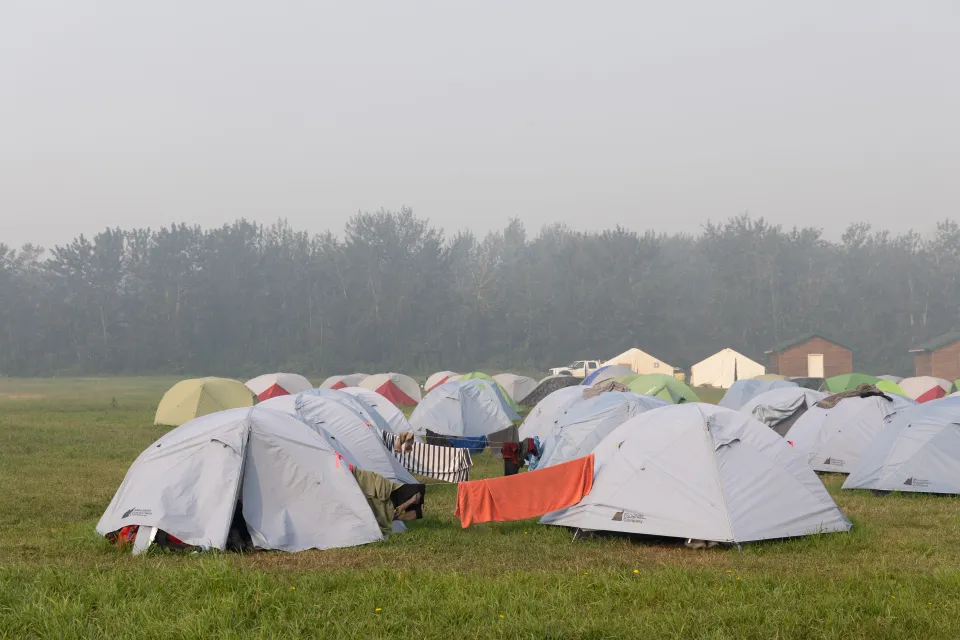 Firefighters camping in Fort Simpson dry clothes on lines strung between tents. Claire McFarlane/Cabin Radio