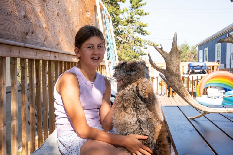 Twelve-year-old Sophia Harman holds hides she tanned herself, a skill her father taught her. Kai Wilson/Cabin Radio