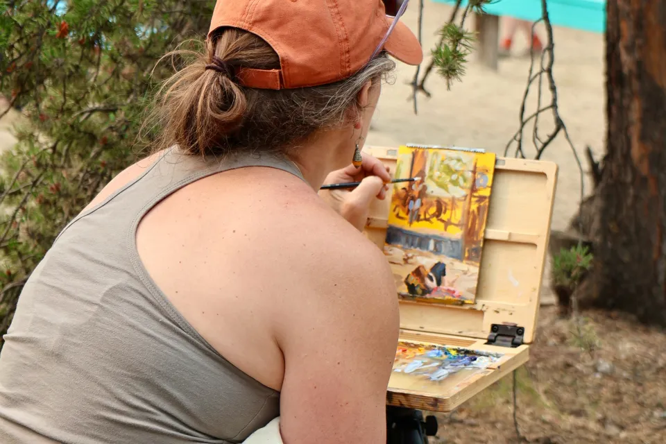 Artist Jen Walden paints a scene at the Cabin Radio Lakefront Stage. Eshana Gohil/Cabin Radio