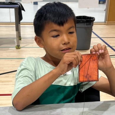 A young participant works on a wallet at a Fort Smith summer camp. Photo: Submitted
