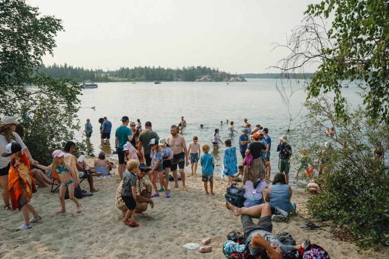 Festival attendees cool off at the lake at Folk on the Rocks 2026. Kai Wilson/Cabin Radio
