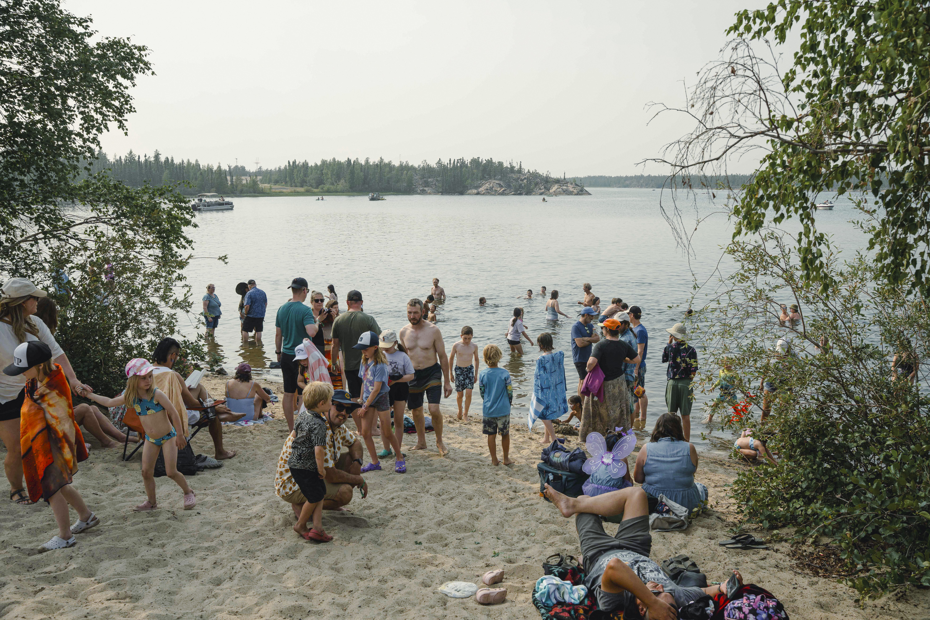 Festival attendees cool off at the lake at Folk on the Rocks 2026. Kai Wilson/Cabin Radio