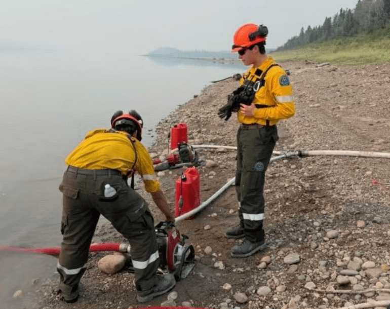 A crew outside Wrigley prepares pumps and hoses for a planned ignition. Photo: NWT Fire