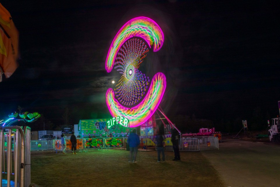 The moon behind the Zipper ride at the fair. Photo: Bill Braden