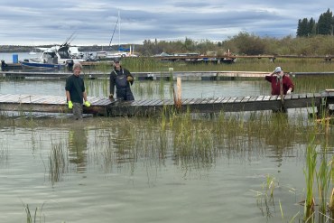 From left to right, Craig Scott, Nielz Huizenga and Kevin Bolstad clean up debris and fIx their docks. Photo: Cathie Bolstad