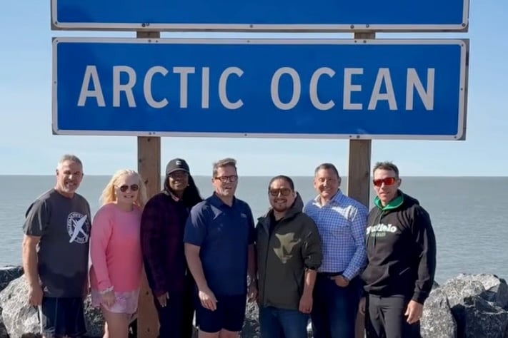 A still from a video published by Bob Zimmer shows David Epp, Lianne Rood, Leslyn Lewis, Zimmer, Billy Morin, Jamie Schmale and John Barlow in front of the Arctic Ocean sign during a recent visit to Tuktoyaktuk.
