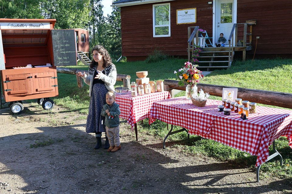 A woman and child stand in front of display tables