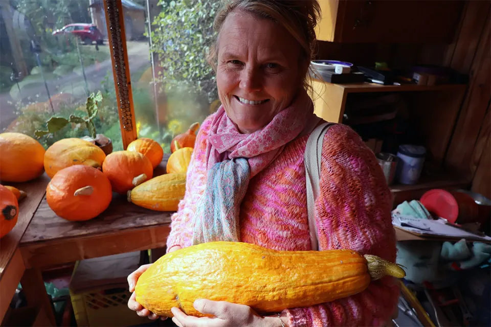 A woman cradles a large squash